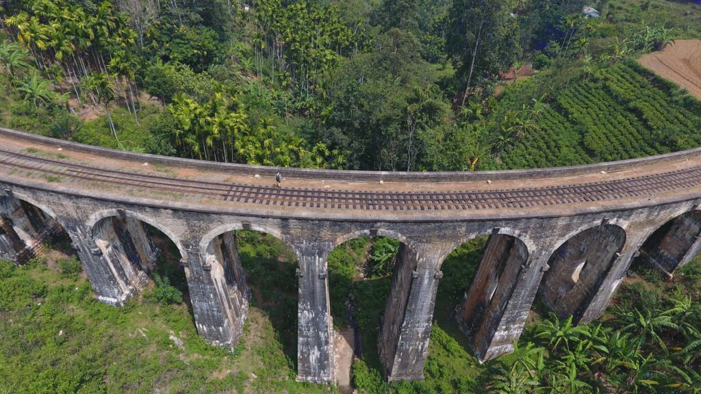 Ella 9 Arch Bridge -Stunning aerial photograph of the iconic Nine Arches Bridge amidst lush greenery in Ella, Sri Lanka.